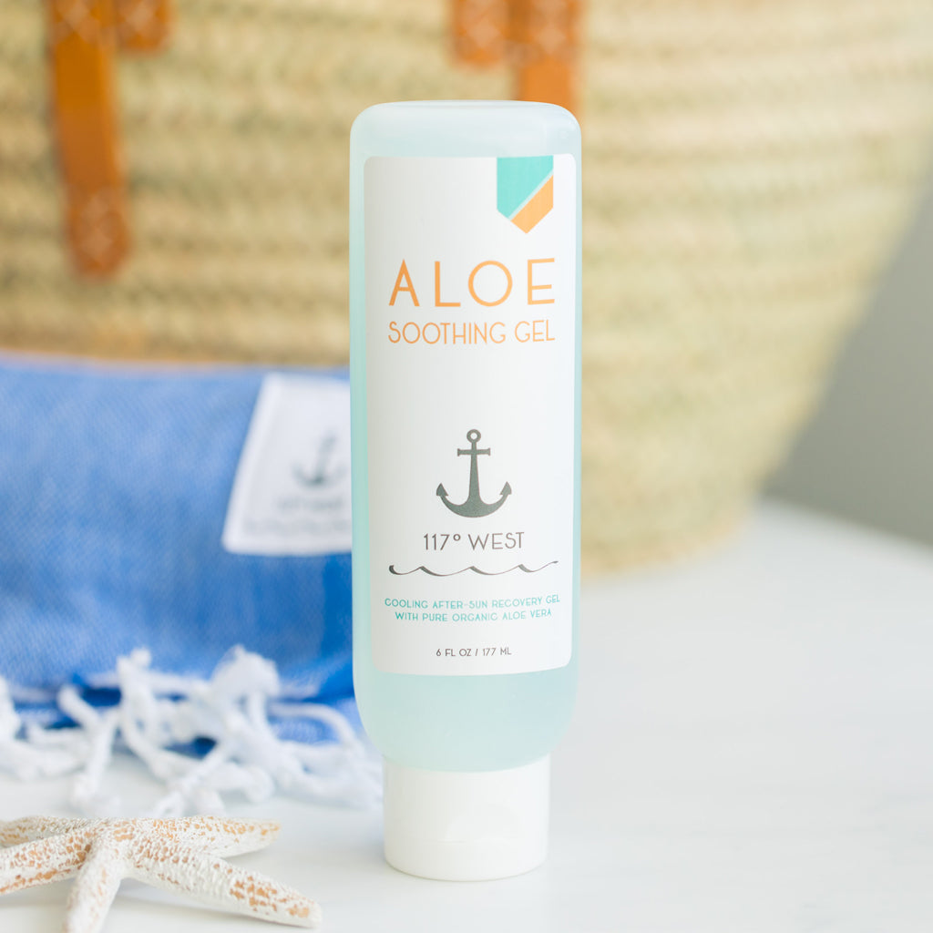 Aloe soothing gel, beach towel and straw bag in background