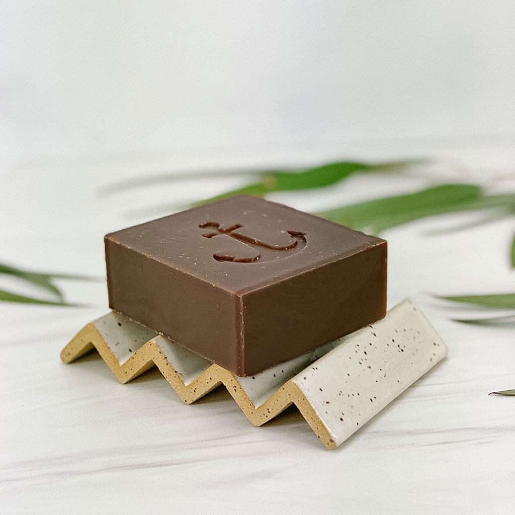 ceramic soap dish with a brown soap bar on top 