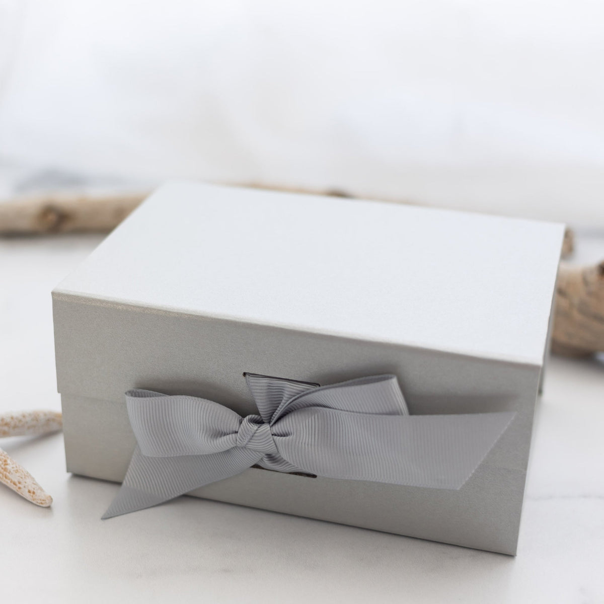 silver gift box with a bow and a white background
