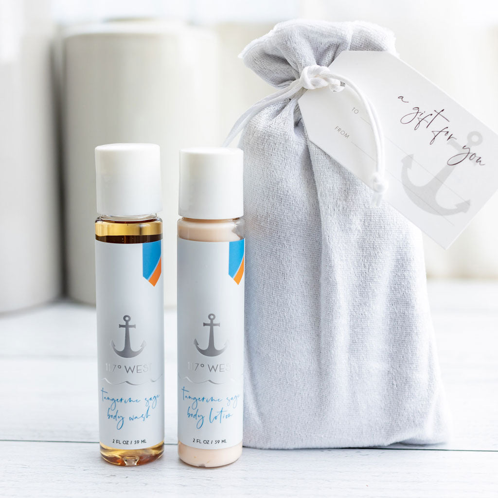 travel size tangerine sage body wash and body lotion pictured with a silver gift bag and custom tag