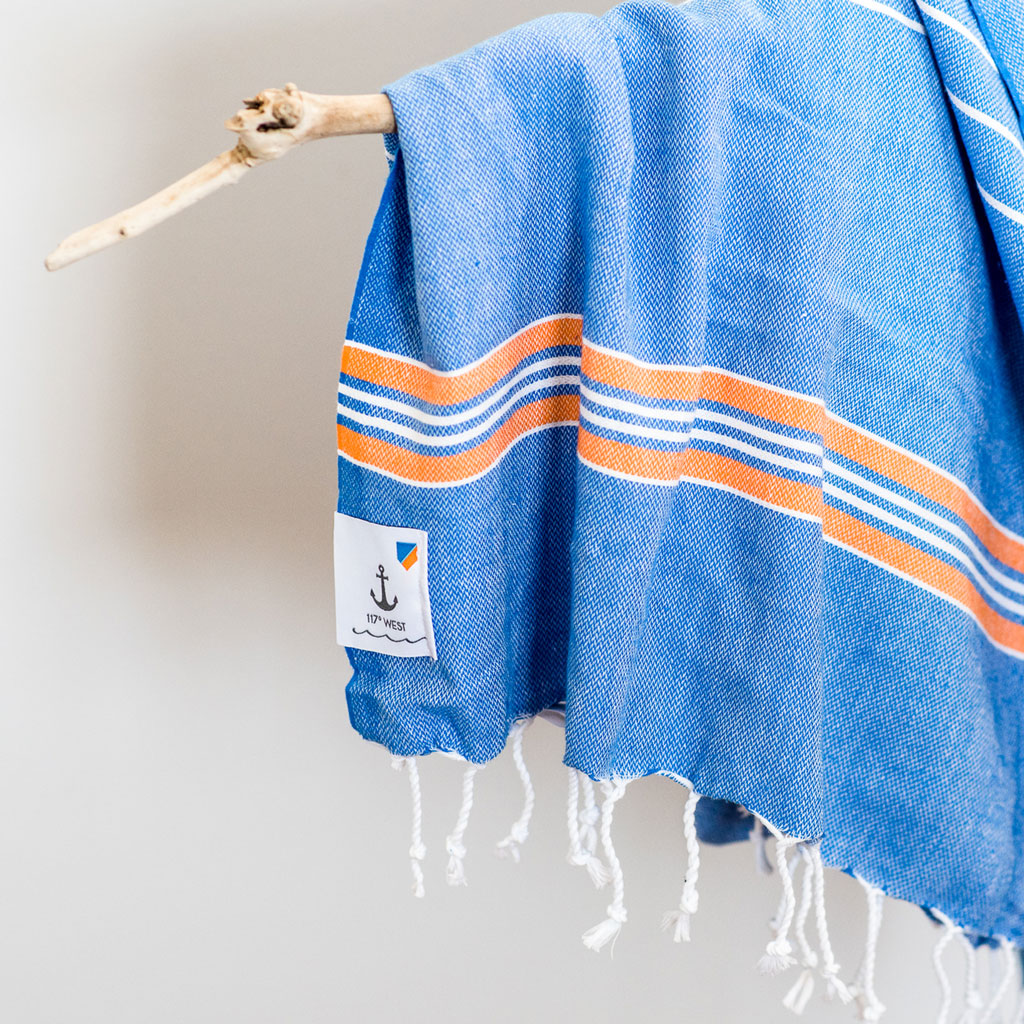 beach turkish towel hanging on branch, white background